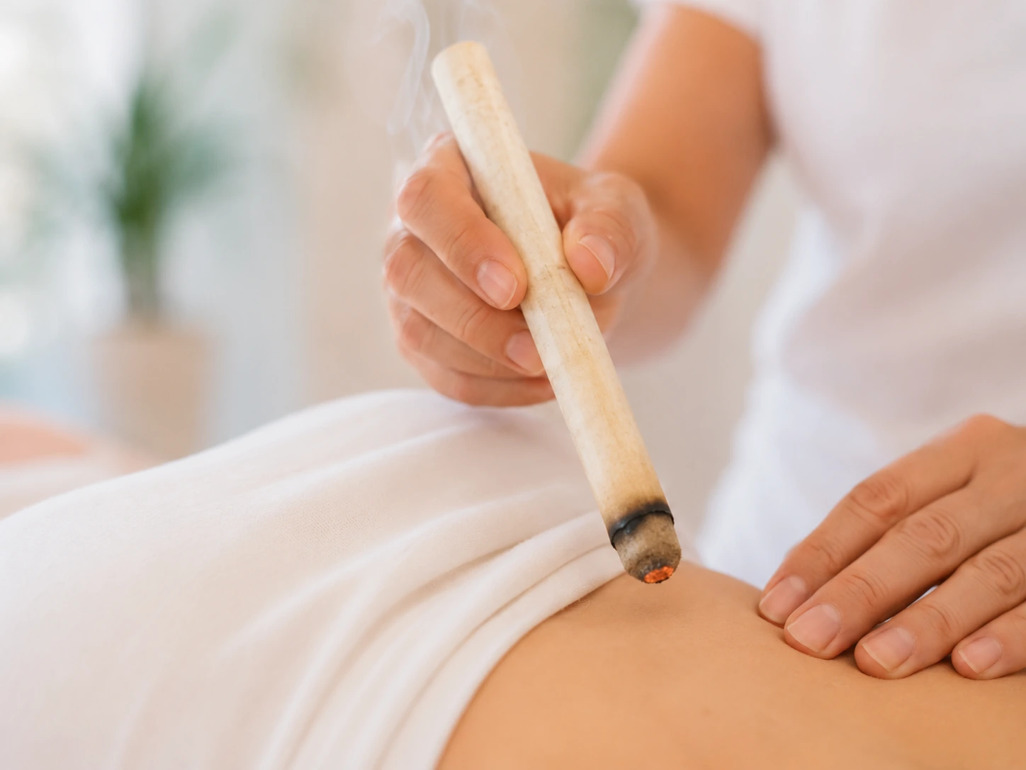 Moxibustion mit glimmendem Beifuss während der Sitzung im Akupunktur Zentrum Uster